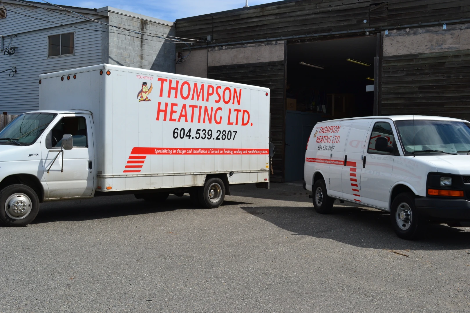 Thompson Heating service vans on a residential construction site